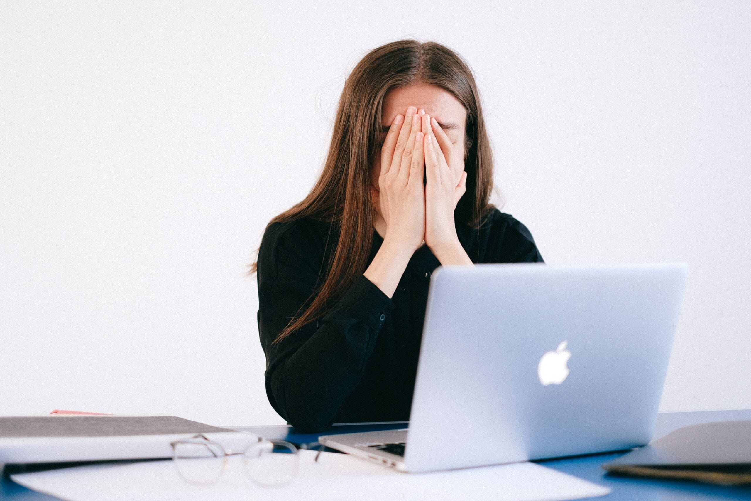 hormoonklachten-werkvloer-vrouw Vrouw met stress en overbelasting achter haar bureau op het werk