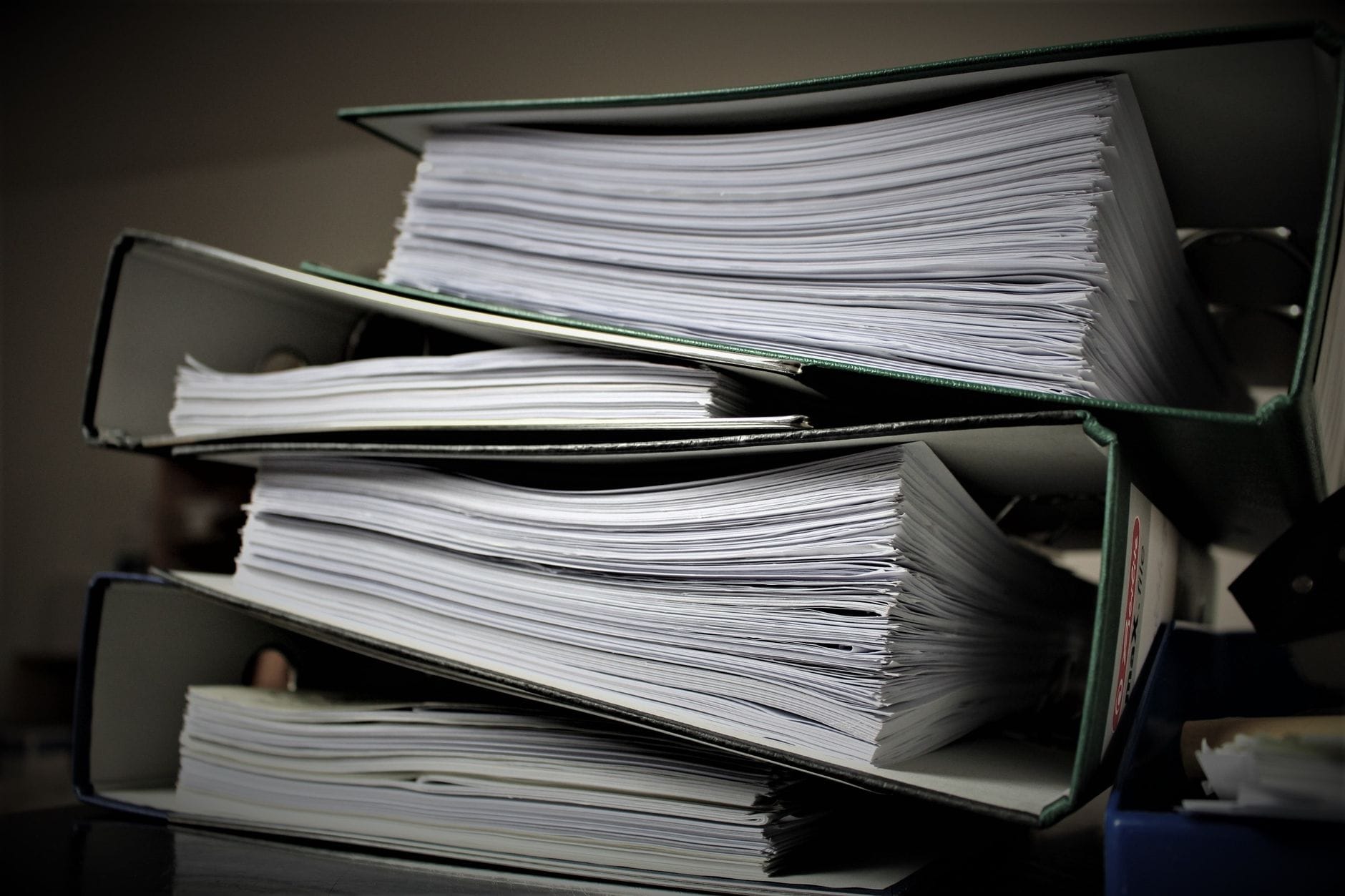 UWV controleert 73.000 WIA-dossiers op fouten in het dagloon Stapel dossiers op een bureau die gecontroleerd worden